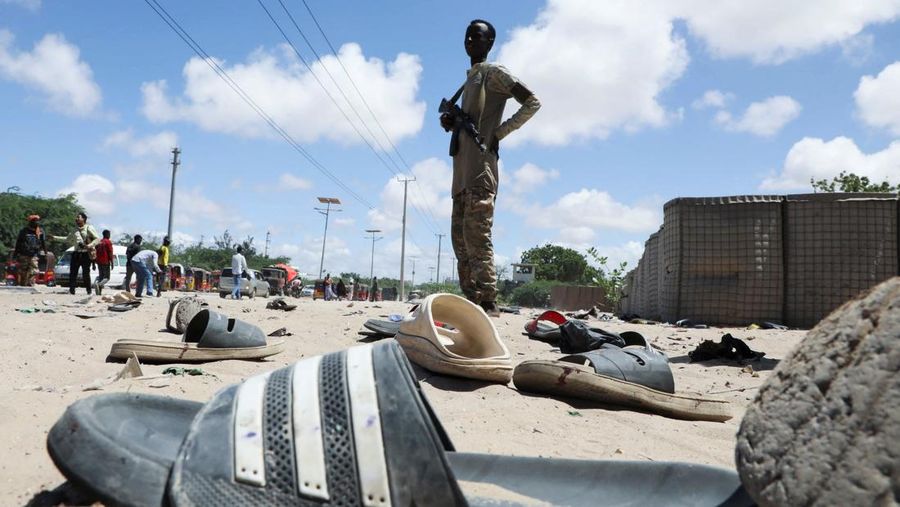 Seorang perwira militer Somalia berjalan melewati sepatu-sepatu yang ditinggalkan di lokasi ledakan yang menargetkan antrean rekrutan muda yang mendaftar di pangkalan militer Damanyo di distrik Hodan, Mogadishu, Somalia, 18 Mei 2025. Seorang perwira militer Somalia berjalan melewati sepatu-sepatu yang ditinggalkan di lokasi ledakan yang menargetkan antrean rekrutan muda yang mendaftar di pangkalan militer Damanyo di distrik Hodan, Mogadishu, Somalia, 18 Mei 2025. (REUTERS/Feisal Omar)