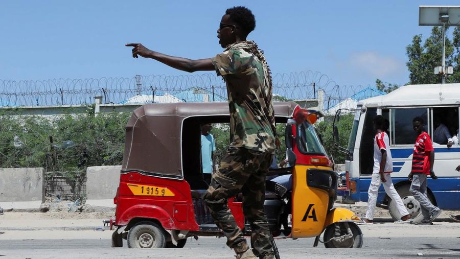 Seorang perwira militer Somalia berjalan melewati sepatu-sepatu yang ditinggalkan di lokasi ledakan yang menargetkan antrean rekrutan muda yang mendaftar di pangkalan militer Damanyo di distrik Hodan, Mogadishu, Somalia, 18 Mei 2025. Seorang perwira militer Somalia berjalan melewati sepatu-sepatu yang ditinggalkan di lokasi ledakan yang menargetkan antrean rekrutan muda yang mendaftar di pangkalan militer Damanyo di distrik Hodan, Mogadishu, Somalia, 18 Mei 2025. (REUTERS/Feisal Omar)