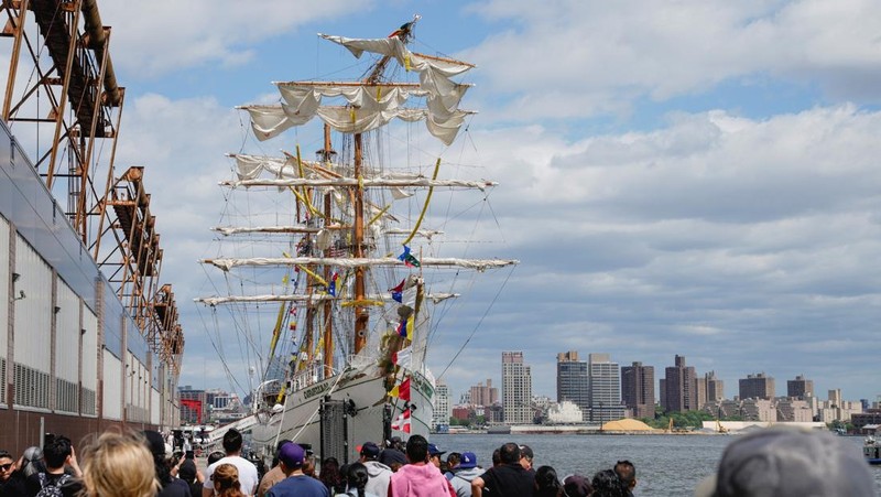 Orang-orang menyaksikan kapal latihan Angkatan Laut Meksiko Cuauhtemoc dengan tiang patah saat berlabuh di dermaga, setelah menabrak Jembatan Brooklyn pada malam hari di New York City, AS, 18 Mei 2025. (REUTERS/Eduardo Munoz)