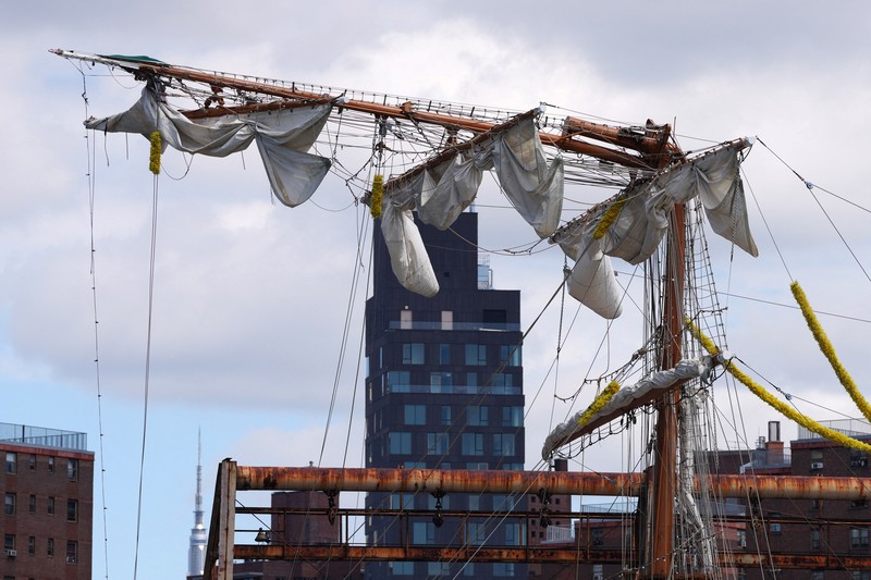 Orang-orang menyaksikan kapal latihan Angkatan Laut Meksiko Cuauhtemoc dengan tiang patah saat berlabuh di dermaga, setelah menabrak Jembatan Brooklyn pada malam hari di New York City, AS, 18 Mei 2025. (REUTERS/Eduardo Munoz)