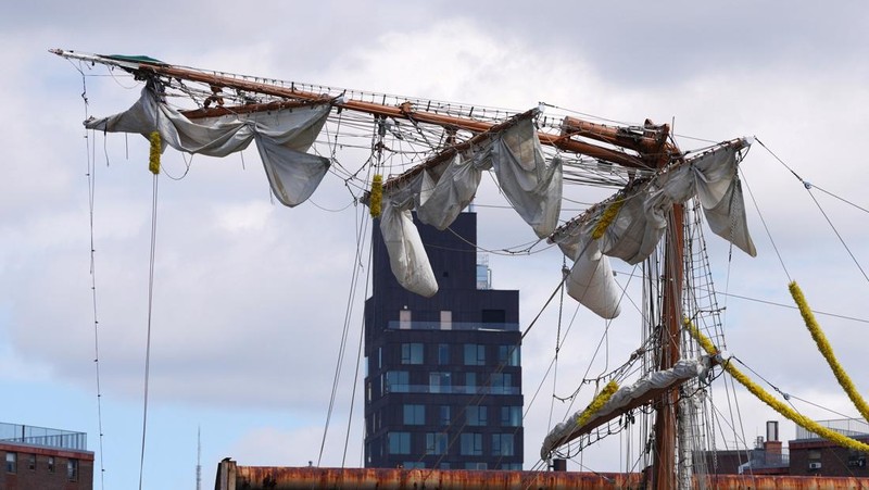 Orang-orang menyaksikan kapal latihan Angkatan Laut Meksiko Cuauhtemoc dengan tiang patah saat berlabuh di dermaga, setelah menabrak Jembatan Brooklyn pada malam hari di New York City, AS, 18 Mei 2025. (REUTERS/Eduardo Munoz)