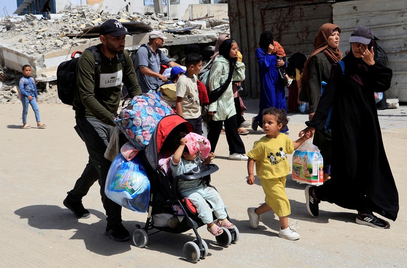 Warga Palestina bergegas meninggalkan rumah mereka di Khan Younis pada Senin (19/4) menyusul perintah evakuasi Israel. (REUTERS/Hatem Khaled)