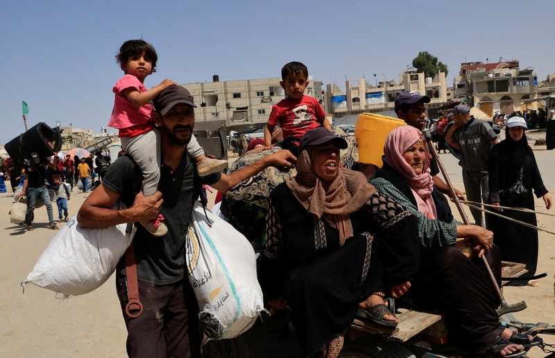 Warga Palestina bergegas meninggalkan rumah mereka di Khan Younis pada Senin (19/4) menyusul perintah evakuasi Israel. (REUTERS/Hatem Khaled)