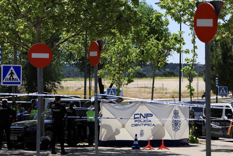 SPAIN-MURDER/UKRAINE Members of the forensic team work at the spot where former Ukrainian politician Andriy Portnov, according to the Spain's Interior Ministry, was shot by unidentified gunmen, outside a school in a wealthy suburb of Madrid, in Madrid, Spain May 21, 2025. REUTERS/Nacho Doce