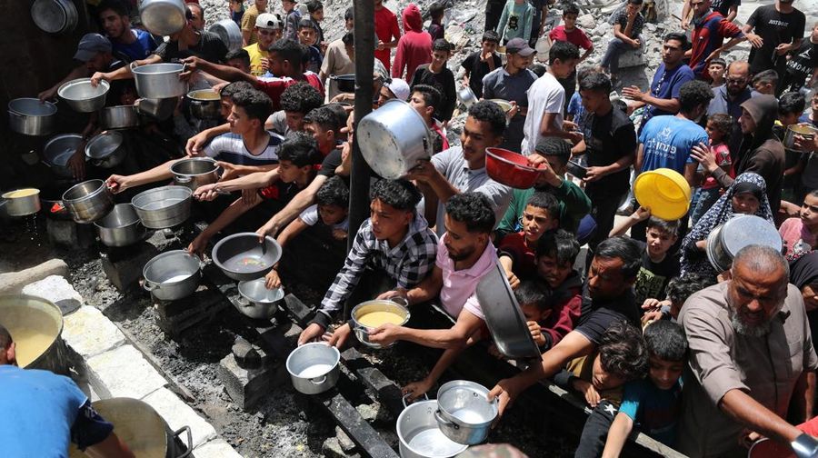 Warga Palestina menunggu untuk menerima makanan yang dimasak oleh dapur amal, di Jabalia, di Jalur Gaza utara, 19 Mei 2025. (REUTERS/Mahmoud Issa)