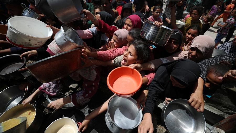 Warga Palestina menunggu untuk menerima makanan yang dimasak oleh dapur amal, di Jabalia, di Jalur Gaza utara, 19 Mei 2025. (REUTERS/Mahmoud Issa)