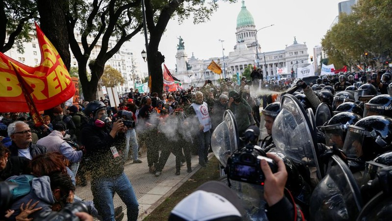Anggota Prefektur Angkatan Laut Argentina menyemprotkan gas anti huru hara kepada anggota pers selama protes mingguan para pensiunan terhadap kebijakan penghematan Presiden Argentina Javier Milei, di luar Kongres Nasional, di Buenos Aires, Argentina, 21 Mei 2025. (REUTERS/Francisco Loureiro)