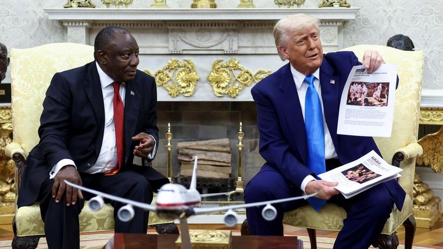 Presiden AS Donald Trump menunjukkan laporan berita yang diduga saat ia bertemu Presiden Afrika Selatan Cyril Ramaphosa di Ruang Oval Gedung Putih di Washington, D.C., AS, 21 Mei 2025. (REUTERS/Kevin Lamarque)