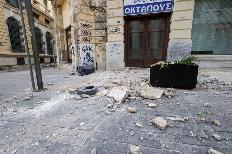 Seorang turis mengambil foto bangunan yang rusak akibat gempa bumi yang melanda Pulau Kreta di Heraklion, Yunani, 22 Mei 2025. (REUTERS/Stefanos Rapanis)