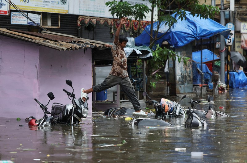 ASIA-WEATHER/INDIA-MONSOON A man wades through a waterlogged street following heavy rainfall in Mumbai, India May 26, 2025. REUTERS/Francis Mascarenhas