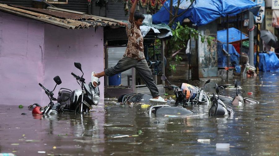 A man wades through a waterlogged street following heavy rainfall in Mumbai, India May 26, 2025. REUTERS/Francis Mascarenhas