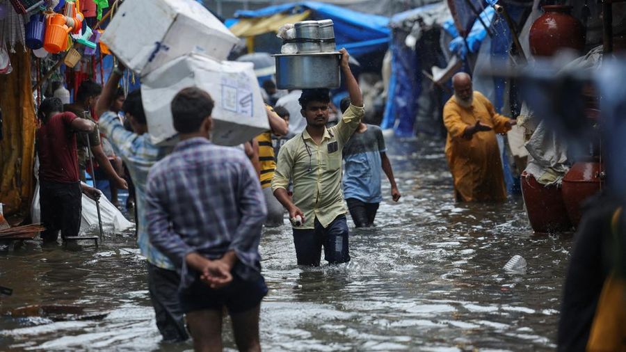 A man wades through a waterlogged street following heavy rainfall in Mumbai, India May 26, 2025. REUTERS/Francis Mascarenhas