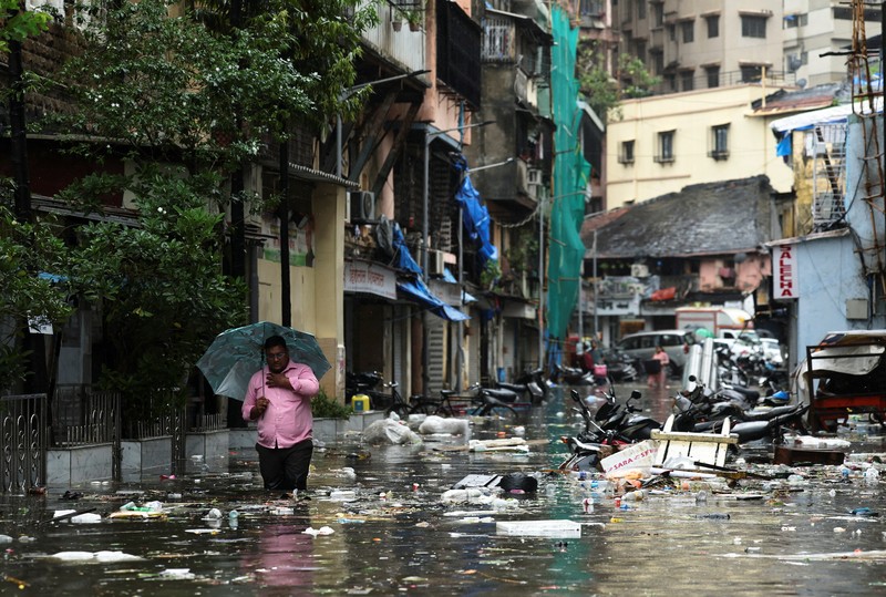 ASIA-WEATHER/INDIA-MONSOON A man wades through a waterlogged street following heavy rainfall in Mumbai, India May 26, 2025. REUTERS/Francis Mascarenhas