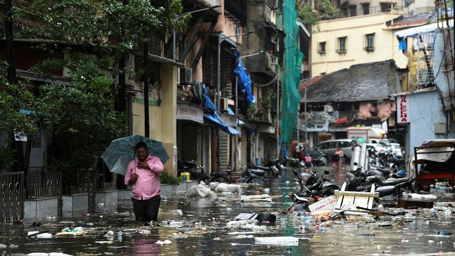 A man wades through a waterlogged street following heavy rainfall in Mumbai, India May 26, 2025. REUTERS/Francis Mascarenhas