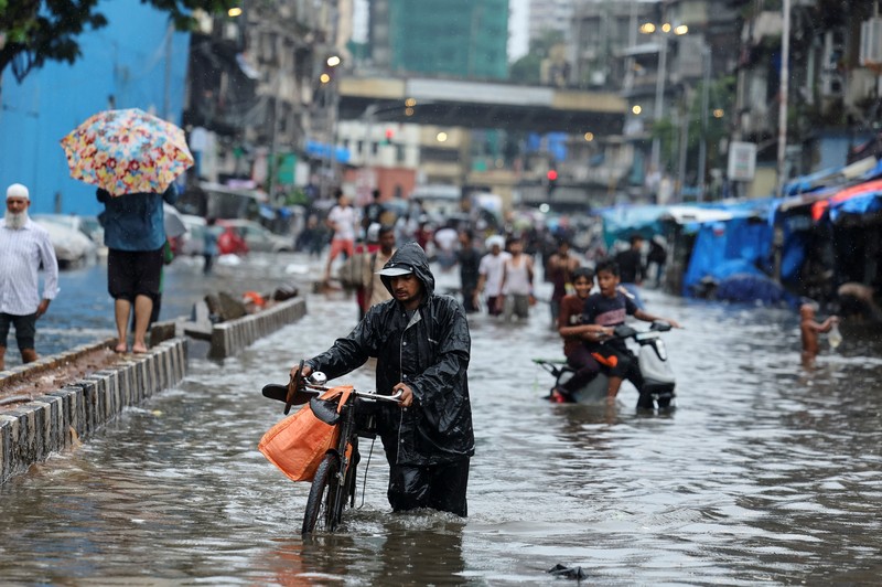 ASIA-WEATHER/INDIA-MONSOON A man wades through a waterlogged street following heavy rainfall in Mumbai, India May 26, 2025. REUTERS/Francis Mascarenhas