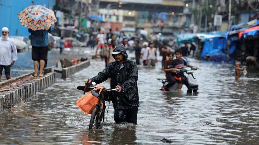 A man wades through a waterlogged street following heavy rainfall in Mumbai, India May 26, 2025. REUTERS/Francis Mascarenhas
