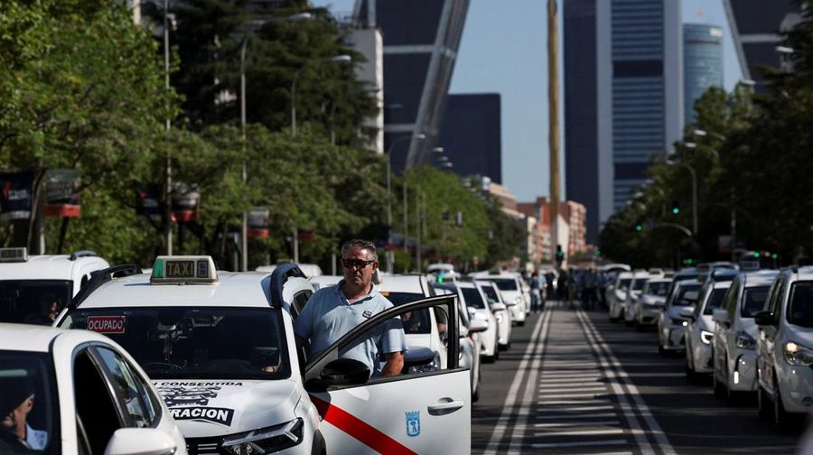 SPAIN-PROTEST/TAXI People cross a street as taxi drivers take part in a protest march against ride-hailing vehicles, in Madrid, Spain, May 28, 2025. REUTERS/Violeta Santos Moura