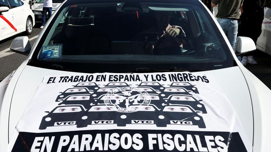 SPAIN-PROTEST/TAXI People cross a street as taxi drivers take part in a protest march against ride-hailing vehicles, in Madrid, Spain, May 28, 2025. REUTERS/Violeta Santos Moura