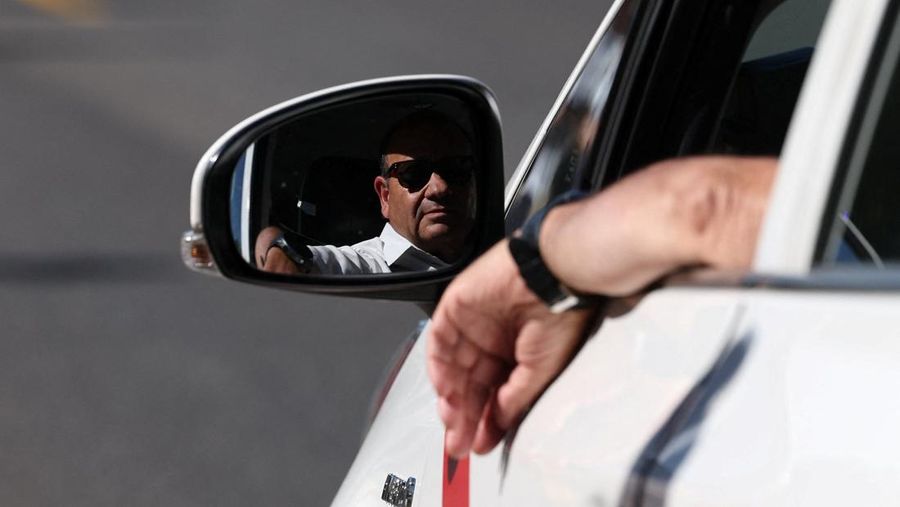 SPAIN-PROTEST/TAXI People cross a street as taxi drivers take part in a protest march against ride-hailing vehicles, in Madrid, Spain, May 28, 2025. REUTERS/Violeta Santos Moura