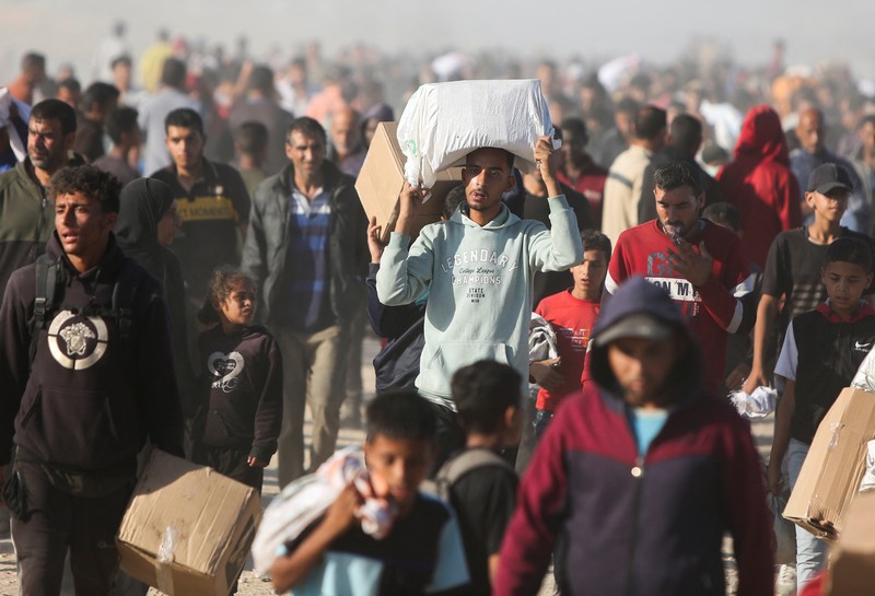 Orang-orang berjalan saat warga Palestina menerima pasokan bantuan dari Yayasan Kemanusiaan Gaza yang didukung AS, dekat wilayah Gaza yang dikenal sebagai koridor Netzarim, 29 Mei 2025. Orang-orang berjalan saat warga Palestina menerima pasokan bantuan dari Yayasan Kemanusiaan Gaza yang didukung AS, dekat wilayah Gaza yang dikenal sebagai koridor Netzarim, 29 Mei 2025. (REUTERS/Ramadan Abed)