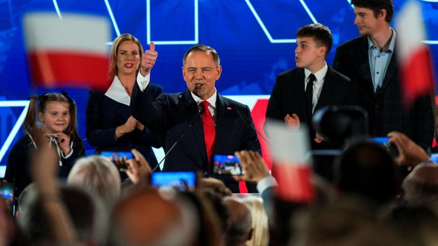 Polish presidential candidate Karol Nawrocki, backed by the main opposition Law and Justice (PiS) party, gesture next to his wife Marta Nawrocka, his sons Antoni and Daniel and daughter Katarzyna, as they react to the exit polls of the second round o