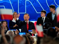 Polish presidential candidate Karol Nawrocki, backed by the main opposition Law and Justice (PiS) party, gesture next to his wife Marta Nawrocka, his sons Antoni and Daniel and daughter Katarzyna, as they react to the exit polls of the second round o