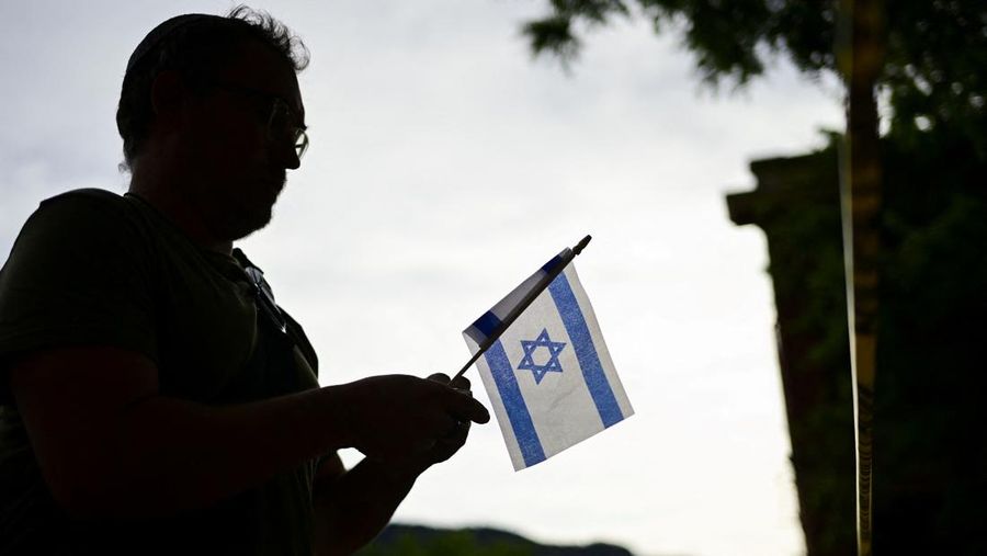 Seeorang memasang bendera Israel di dekat lokasi serangan yang melukai banyak orang, di Boulder, Colorado, AS, 1 Juni 2025. (REUTERS/Mark Makela)
