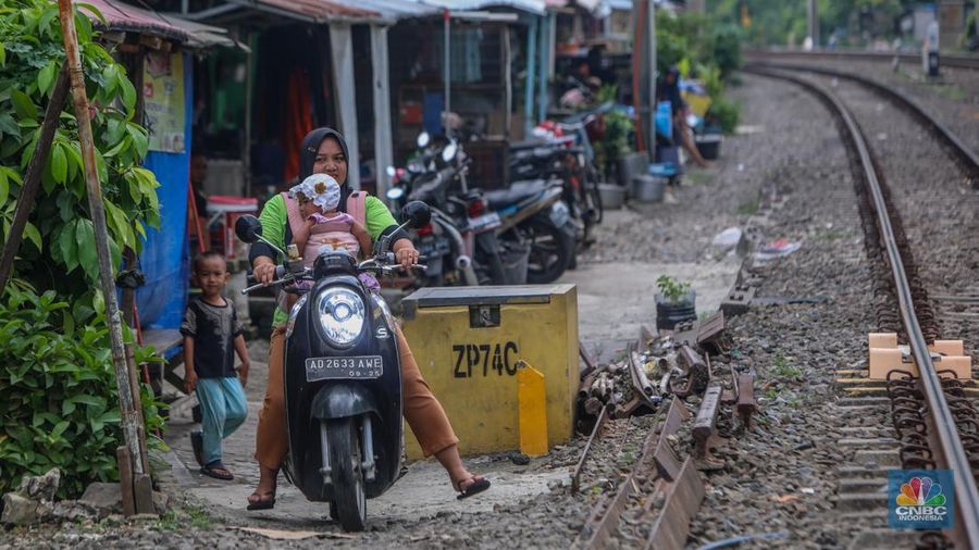 Suasana aktivitas warga pada permukiman kumuh yang berdekatan dengan rel kereta di Jakarta, Senin (2/6/2025). (CNBC Indonesia/Faisal Rahman)