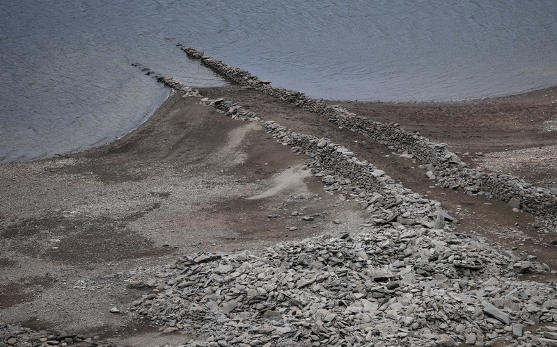 Pemandangan drone menunjukkan bagian dasar Waduk Haweswater yang terbuka, di mana meskipun baru-baru ini terjadi hujan, permukaan airnya tetap rendah tidak sesuai musim, di Haweswater, Inggris, 2 Juni 2025. (REUTERS/Phil Noble)