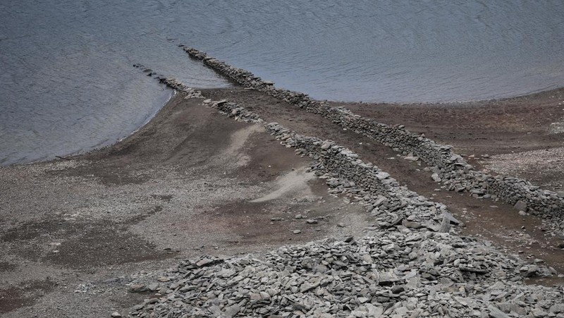 Pemandangan drone menunjukkan bagian dasar Waduk Haweswater yang terbuka, di mana meskipun baru-baru ini terjadi hujan, permukaan airnya tetap rendah tidak sesuai musim, di Haweswater, Inggris, 2 Juni 2025. (REUTERS/Phil Noble)