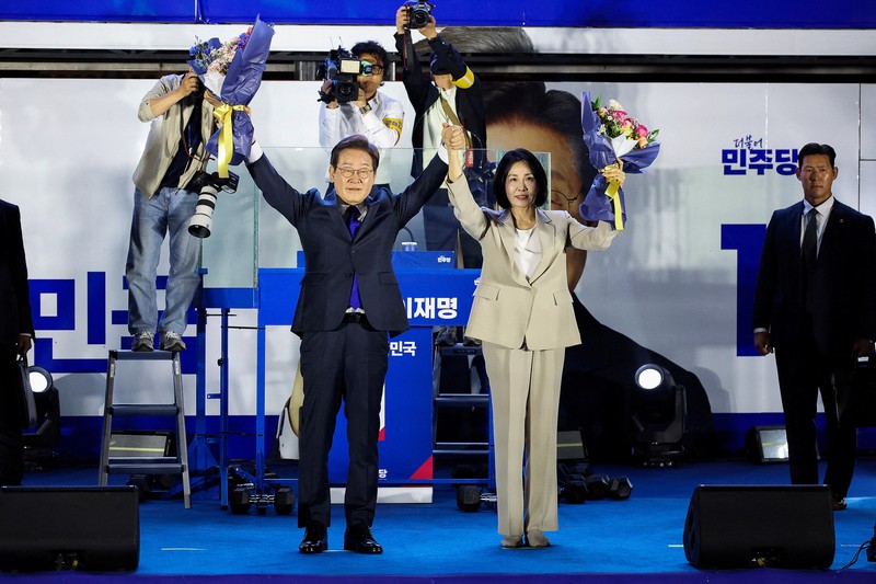 Lee Jae-myung, kandidat presiden dari Partai Demokrat Korea Selatan, dan istrinya Kim Hye-kyung memberi isyarat, di depan Majelis Nasional di Seoul, Korea Selatan, 4 Juni 2025. Lee Jae-myung, kandidat presiden dari Partai Demokrat Korea Selatan, dan istrinya Kim Hye-kyung memberi isyarat, di depan Majelis Nasional di Seoul, Korea Selatan, 4 Juni 2025. (REUTERS/Kim Hong-Ji)