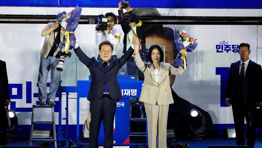 Lee Jae-myung, kandidat presiden dari Partai Demokrat Korea Selatan, dan istrinya Kim Hye-kyung memberi isyarat, di depan Majelis Nasional di Seoul, Korea Selatan, 4 Juni 2025. Lee Jae-myung, kandidat presiden dari Partai Demokrat Korea Selatan, dan istrinya Kim Hye-kyung memberi isyarat, di depan Majelis Nasional di Seoul, Korea Selatan, 4 Juni 2025. (REUTERS/Kim Hong-Ji)