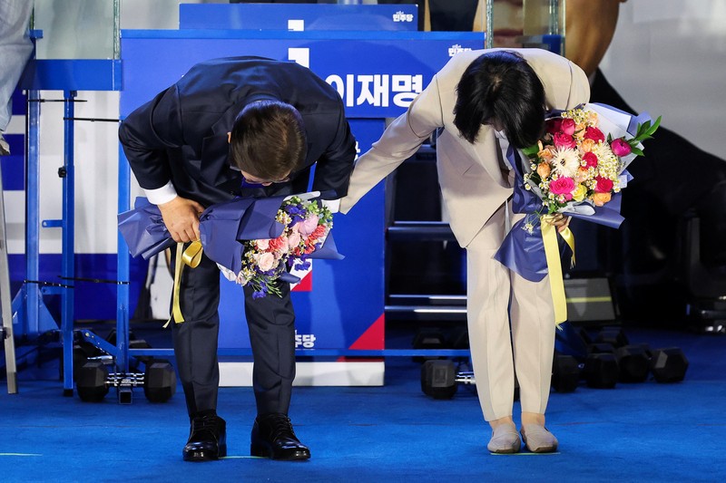Lee Jae-myung, kandidat presiden dari Partai Demokrat Korea Selatan, dan istrinya Kim Hye-kyung memberi isyarat, di depan Majelis Nasional di Seoul, Korea Selatan, 4 Juni 2025. Lee Jae-myung, kandidat presiden dari Partai Demokrat Korea Selatan, dan istrinya Kim Hye-kyung memberi isyarat, di depan Majelis Nasional di Seoul, Korea Selatan, 4 Juni 2025. (REUTERS/Kim Hong-Ji)