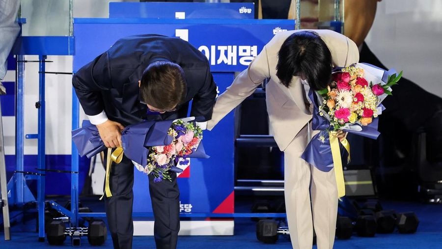Lee Jae-myung, kandidat presiden dari Partai Demokrat Korea Selatan, dan istrinya Kim Hye-kyung memberi isyarat, di depan Majelis Nasional di Seoul, Korea Selatan, 4 Juni 2025. Lee Jae-myung, kandidat presiden dari Partai Demokrat Korea Selatan, dan istrinya Kim Hye-kyung memberi isyarat, di depan Majelis Nasional di Seoul, Korea Selatan, 4 Juni 2025. (REUTERS/Kim Hong-Ji)