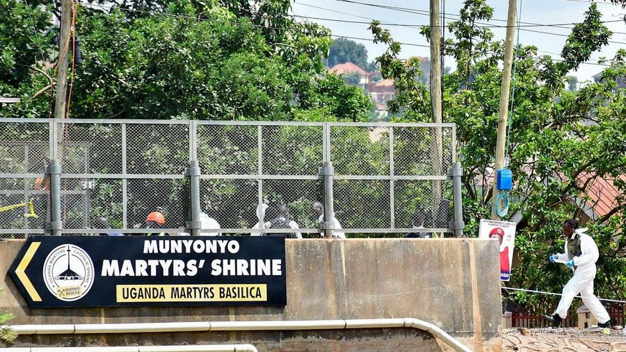 Orang-orang menyaksikan para ahli forensik mengamankan lokasi ledakan bom di dekat Kuil Martir Munyonyo, sebuah kuil Katolik Roma saat warga Uganda berkumpul untuk merayakan Hari Martir, yang memperingati umat Kristen yang terbunuh karena iman mereka pada abad ke-19, di pinggiran kota Munyonyo, Kampala, Uganda, 3 Juni 2025. Orang-orang menyaksikan para ahli forensik mengamankan lokasi ledakan bom di dekat Kuil Martir Munyonyo, sebuah kuil Katolik Roma saat warga Uganda berkumpul untuk merayakan Hari Martir, yang memperingati umat Kristen yang terbunuh karena iman mereka pada abad ke-19, di pinggiran kota Munyonyo, Kampala, Uganda, 3 Juni 2025. (REUTERS/Abubaker Lubowa)