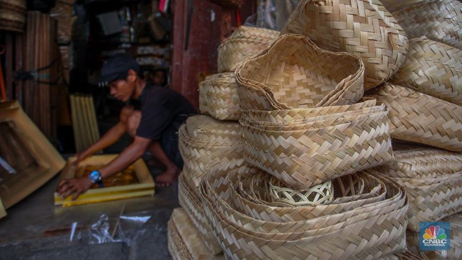 Pedagang besek bambu melayani pembeli di lapaknya di kawasan Jatinegara, Jakarta, Rabu (4/6/2025). (CNBC Indonesia/Faisal Rahman)