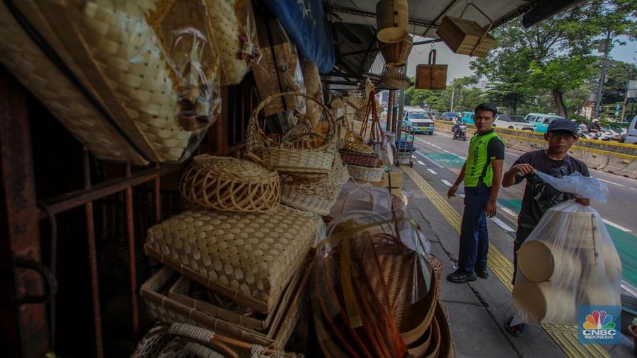 Pedagang besek bambu melayani pembeli di lapaknya di kawasan Jatinegara, Jakarta, Rabu (4/6/2025). (CNBC Indonesia/Faisal Rahman)