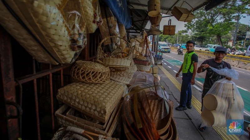 Pedagang besek bambu melayani pembeli di lapaknya di kawasan Jatinegara, Jakarta, Rabu (4/6/2025). (CNBC Indonesia/Faisal Rahman)