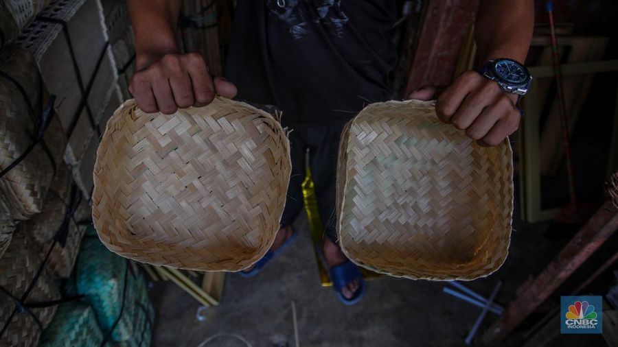 Pedagang besek bambu melayani pembeli di lapaknya di kawasan Jatinegara, Jakarta, Rabu (4/6/2025). (CNBC Indonesia/Faisal Rahman)