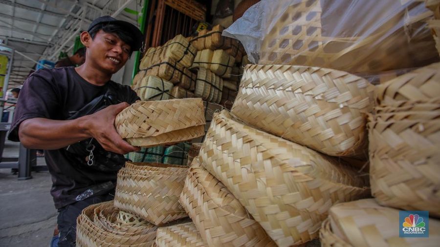 Pedagang besek bambu melayani pembeli di lapaknya di kawasan Jatinegara, Jakarta, Rabu (4/6/2025). (CNBC Indonesia/Faisal Rahman)