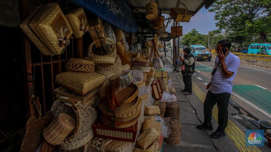 Pedagang besek bambu melayani pembeli di lapaknya di kawasan Jatinegara, Jakarta, Rabu (4/6/2025). (CNBC Indonesia/Faisal Rahman)