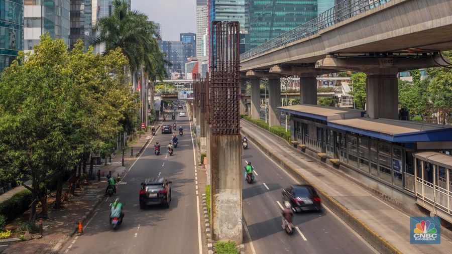 Pengendara melintas di dekat tiang bekas proyek monorel Jakarta di kawasan Jalan HR Rasuna Said, Jakarta, Rabu (4/6/2025). (CNBC Indonesia/Faisal Rahman)