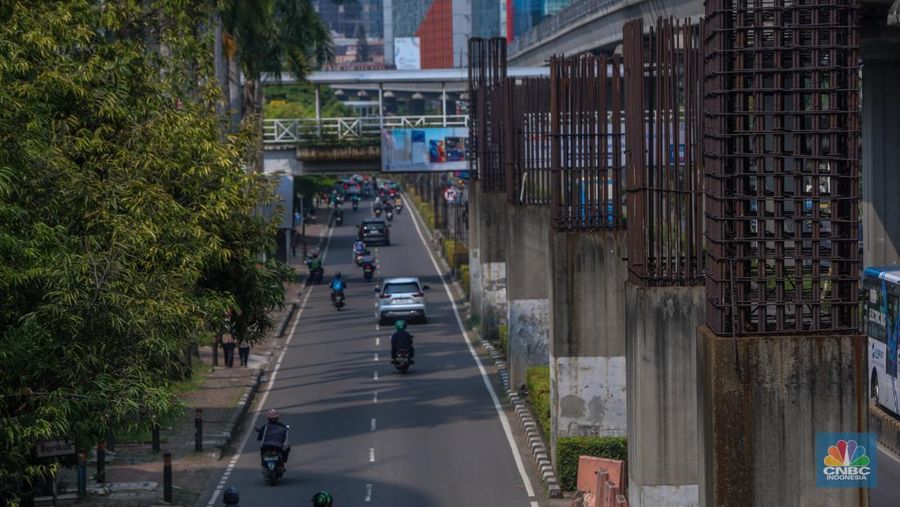 Pengendara melintas di dekat tiang bekas proyek monorel Jakarta di kawasan Jalan HR Rasuna Said, Jakarta, Rabu (4/6/2025). (CNBC Indonesia/Faisal Rahman)