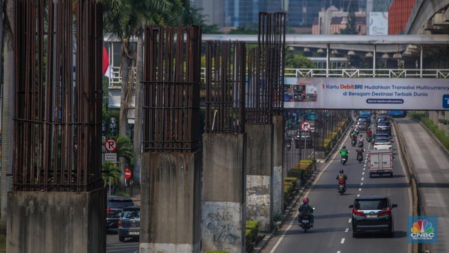 Pengendara melintas di dekat tiang bekas proyek monorel Jakarta di kawasan Jalan HR Rasuna Said, Jakarta, Rabu (4/6/2025). (CNBC Indonesia/Faisal Rahman)