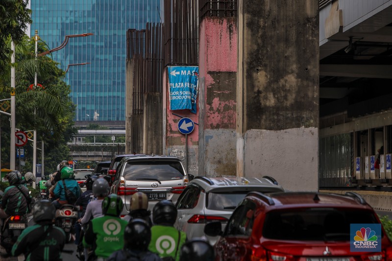 Pengendara melintas di dekat tiang bekas proyek monorel Jakarta di kawasan Jalan HR Rasuna Said, Jakarta, Rabu (4/6/2025). (CNBC Indonesia/Faisal Rahman)