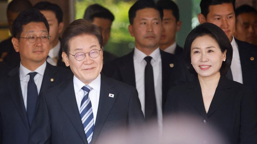 Lee Jae-myung, kandidat presiden dari Partai Demokrat Korea Selatan, dan istrinya Kim Hye-kyung memberi isyarat, di depan Majelis Nasional di Seoul, Korea Selatan, 4 Juni 2025. Lee Jae-myung, kandidat presiden dari Partai Demokrat Korea Selatan, dan istrinya Kim Hye-kyung memberi isyarat, di depan Majelis Nasional di Seoul, Korea Selatan, 4 Juni 2025. (REUTERS/Kim Hong-Ji)