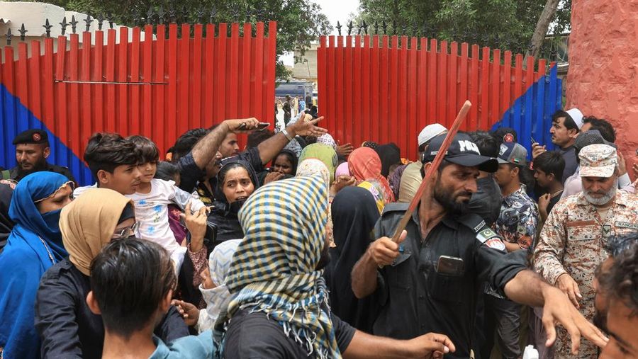 Seorang petugas polisi dengan tongkat bereaksi saat membubarkan anggota keluarga tahanan, setelah puluhan tahanan melarikan diri dari Penjara Malir, di pinggiran Karachi, Pakistan, 3 Juni 2025. (REUTERS/Akhtar Soomro)