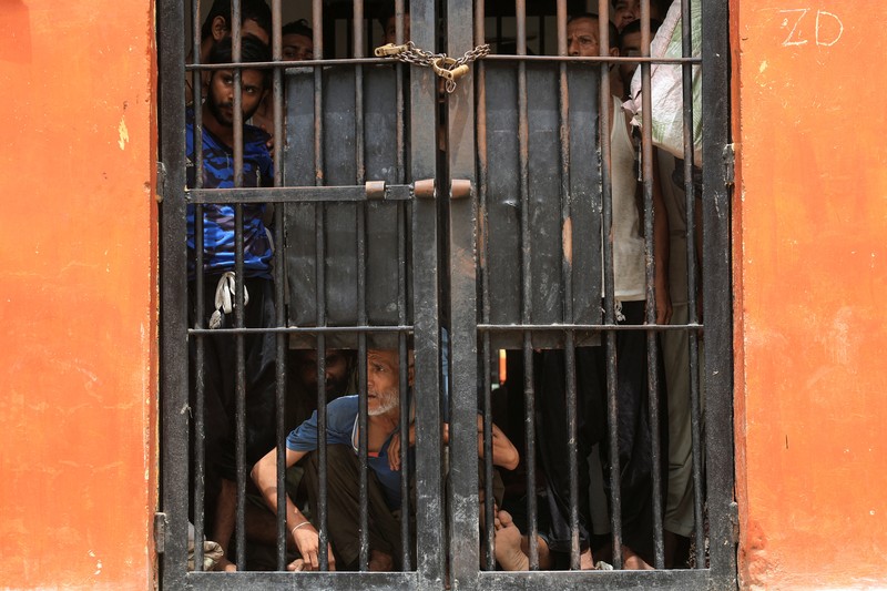 Seorang petugas polisi dengan tongkat bereaksi saat membubarkan anggota keluarga tahanan, setelah puluhan tahanan melarikan diri dari Penjara Malir, di pinggiran Karachi, Pakistan, 3 Juni 2025. (REUTERS/Akhtar Soomro)