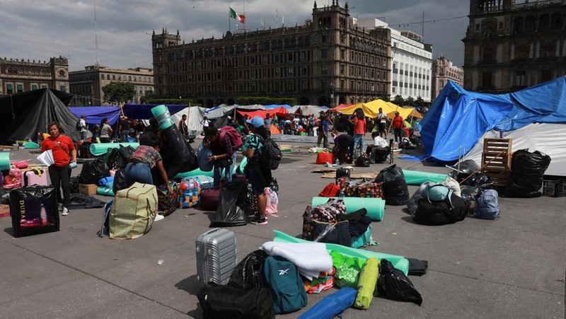 People remove their belongings, tents and tarps set up by members of the National Coordination of Education Workers (CNTE) at the site of a protest to demand dialogue with the government regarding their labor and educational demands, at Zocalo square, in Mexico City, Mexico June 6, 2025. REUTERS/Henry Romero
