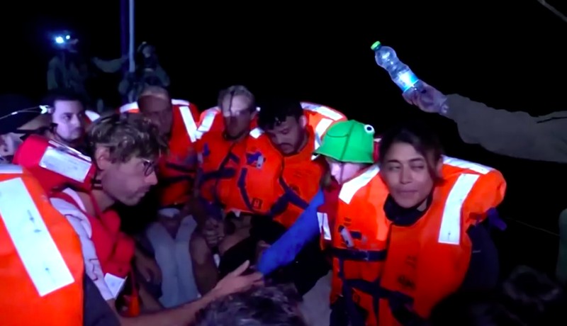 Sebuah video yang dirilis oleh Kementerian Luar Negeri Israel pada hari Senin (9 Juni) menunjukkan para awak kapal diberi roti lapis dan air minum kemasan setelah kapal mereka dinaiki oleh pasukan Israel pada malam hari. (Tangkapan Layar Reuters TV)